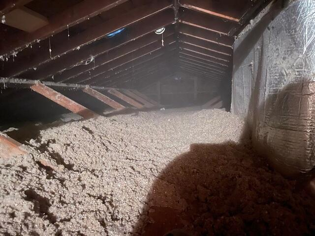 Thick uniform layer of newly installed Tru-Soft insulation covering floor framing and joists inside a residential attic space in Minneapolis Minnesota