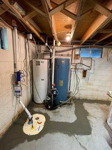 A newly installed DoubleSafe sump pump basin cleanly sealed into a fresh concrete floor next to a water heater and blue water tank in a Cornucopia, WI cabin basement.