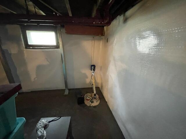A newly installed sub-floor drainage system, white wall panels, and an updated sump pump pit in a Superior, WI basement.