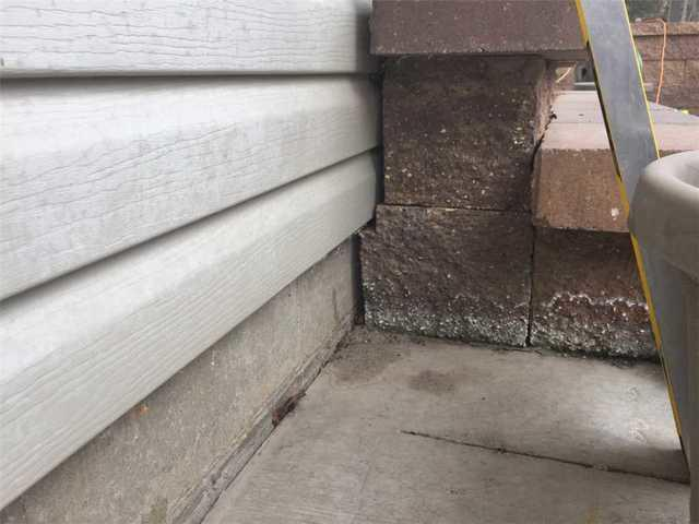 Sinking concrete patio slabs accumulating water against the foundation wall in Bemidji MN