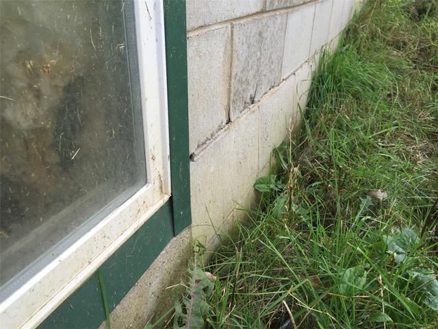 Bowing exterior basement wall showing structural cracking and leaning in Hinckley MN before foundation repair