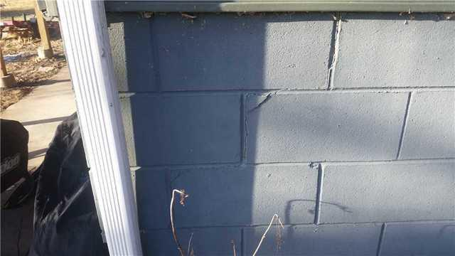 Stair-step structural cracking running through a concrete block foundation wall before repair in Rush City Minnesota