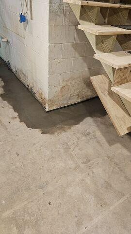 Damp basement floor next to a bowing wall in Remer MN