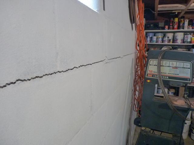 Horizontal crack running across a bowing concrete block basement wall