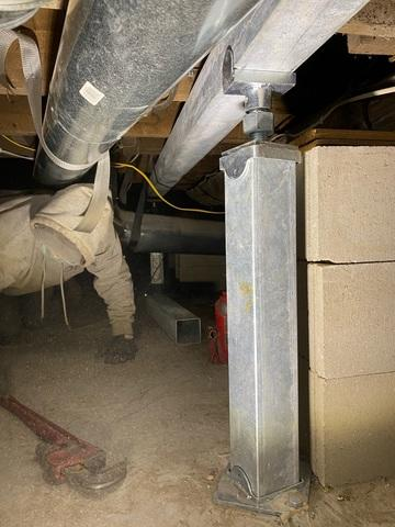 An active crawl space foundation repair project near Bemidji, MN, featuring a galvanized steel SmartJack column installed vertically next to stacked concrete blocks beneath an overhead air duct.